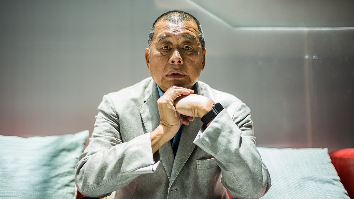 Jimmy Lai apoya la barbilla en el brazo.